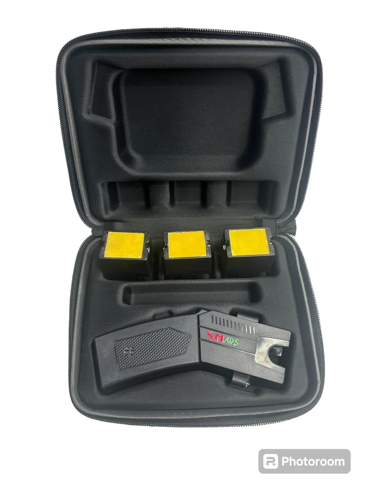 The Air Teaser in its open hard carry case, showing the device and three yellow-faced cartridges